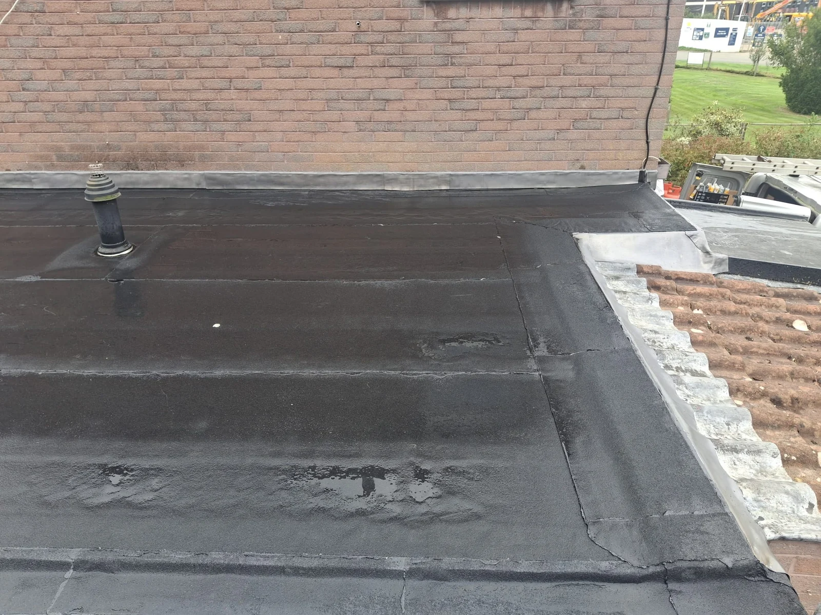 Flat-roof covering beside the adjoining pitched-roof junction